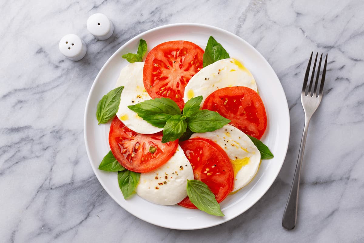 Insalta caprese is Fresh mozzarella, ripe tomatoes, and fragrant basil,