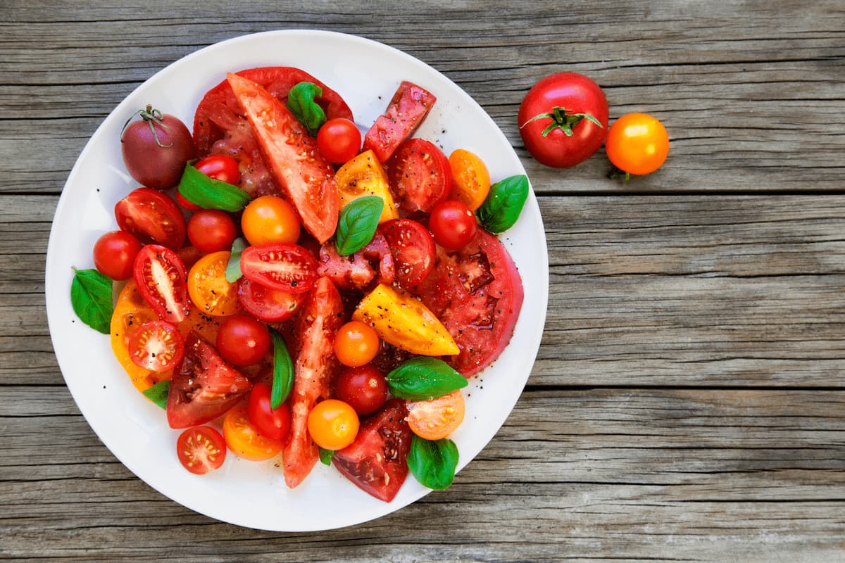 Ripe tomatoes are sliced and tossed with olive oil