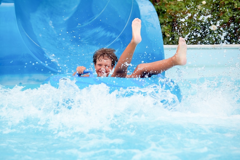 an 8 year old boy is riding in the water Park with fun